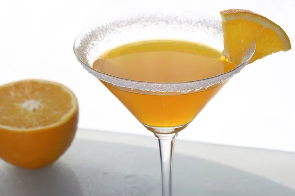 A close-up of martini glass with orange cocktail and a piece of citrus — Stock Photo, Image