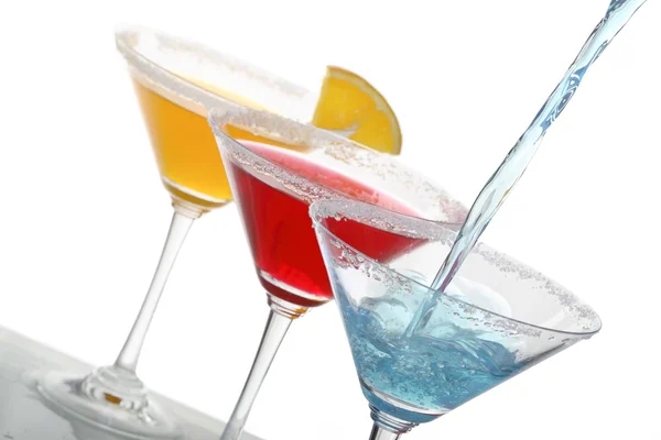 Una vista ravvicinata del bicchiere da martini con diversi cocktail colorati e un pezzo di arancia — Foto Stock