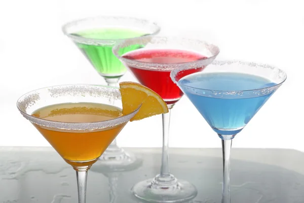 Una vista ravvicinata del bicchiere da martini con diversi cocktail colorati e un pezzo di arancia — Foto Stock