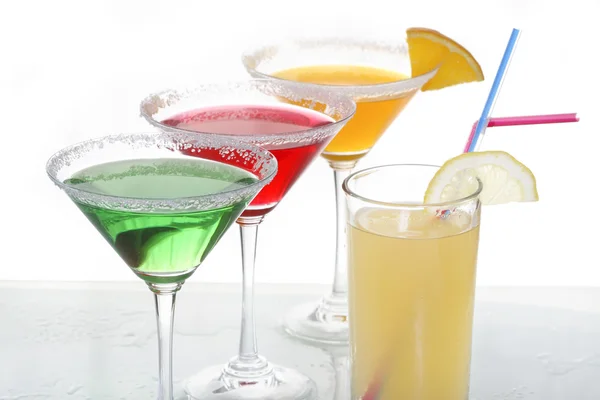 A close up view of martini glass with different colored cocktails and a piece of orange — Stock Photo, Image