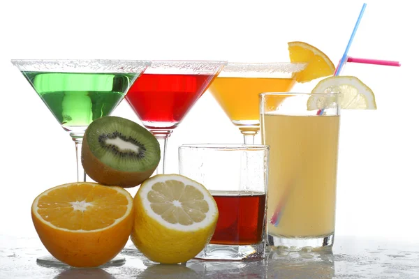 A close up view of martini glass with different colored cocktails, whisky and fruit — Stock Photo, Image