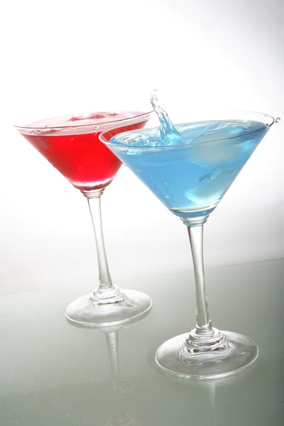 Una foto di bicchiere da martini con cocktail rossi e blu e ghiaccio — Foto Stock