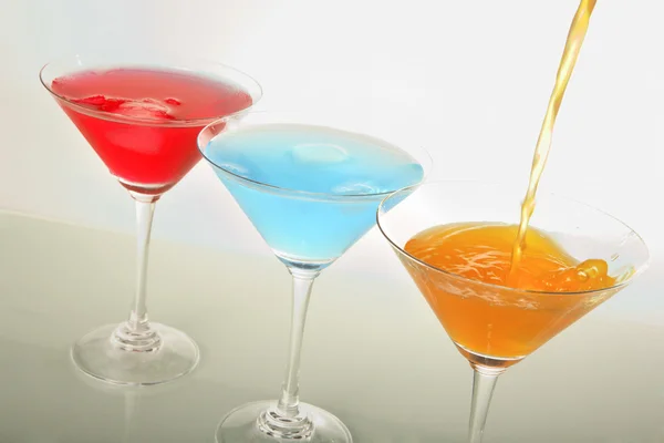 A photo of martini glass with red & blue cocktails and ice — Stock Photo, Image
