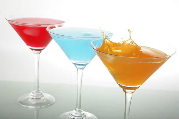 Uma foto de vidro martini com coquetéis vermelhos e azuis e gelo — Fotografia de Stock