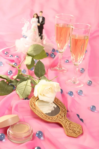 Ein Foto von Hochzeitstortenpuppen, Rose und Brille über rosa — Stockfoto