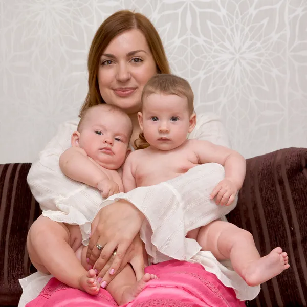 Молодая мать с двумя очаровательными дочерьми близнецы девочки — стоковое фото