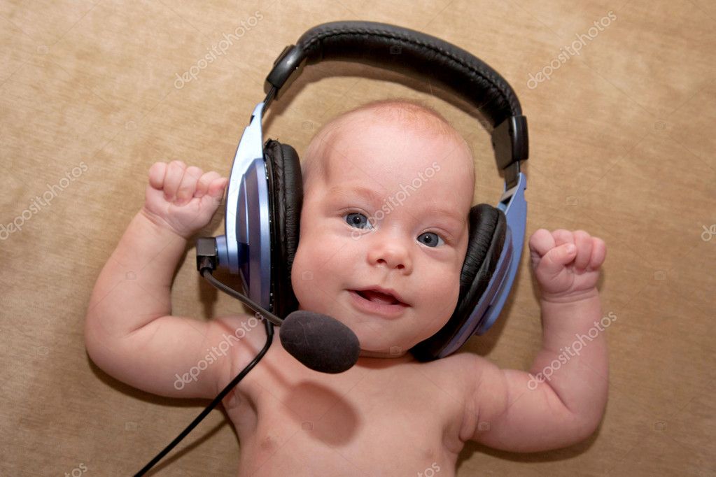 Nice newborn baby boy with blue eyes smiling wearing a headset. ⬇ Stock