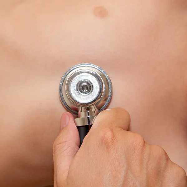 Pediatra sosteniendo un estetoscopio en el pecho del bebé . — Foto de Stock