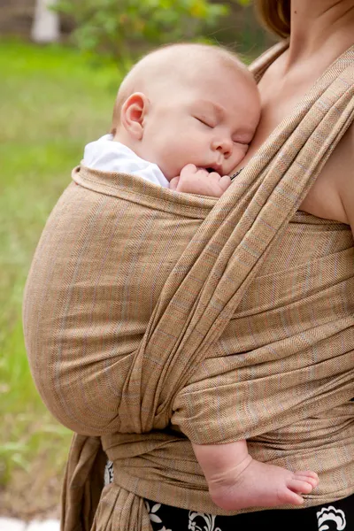 Bebê recém-nascido dormindo em uma funda — Fotografia de Stock