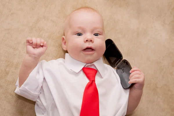 Новорожденный ребенок разговаривает по мобильному телефону — стоковое фото