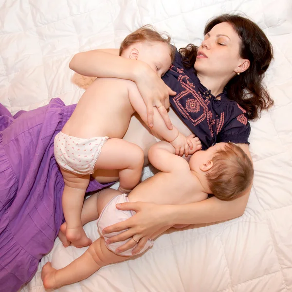 Iki küçük kız ikiz kız bebek emzirme — Stok fotoğraf