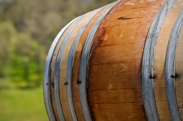 緑のブドウ畑の背景を持つワイン樽 — ストック写真
