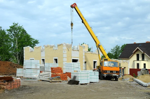 stock image Construction of the new house with a crane.