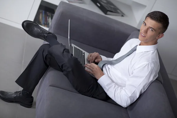 Framgångsrik affärsman arbetar med en bärbar dator och sitter — Stockfoto