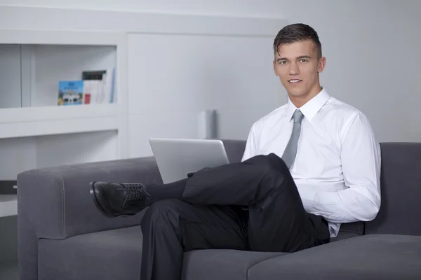 Успешный бизнесмен, работающий с ноутбуком и сидящий — стоковое фото