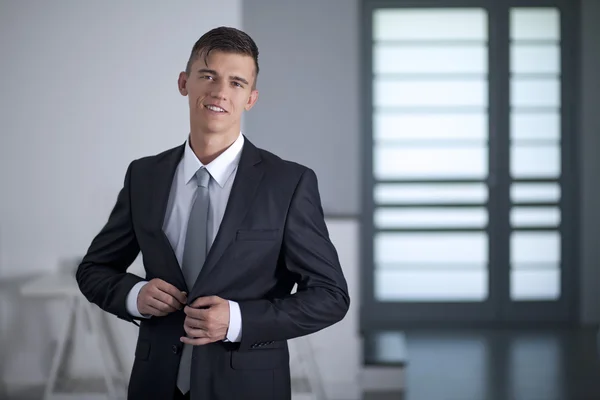 Businessman in suit poses pulling his suit lapels — Stock Photo, Image