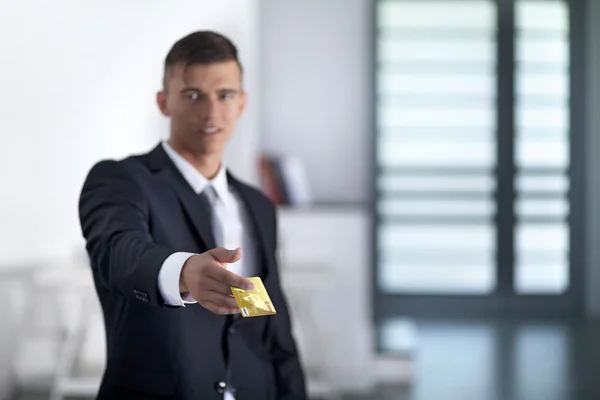 Молодий успішний бізнесмен тримає кредитну картку — стокове фото