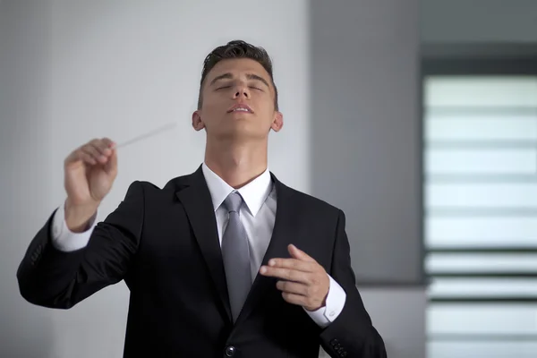Businessman conducting his work and business with his baton — Stock Photo, Image
