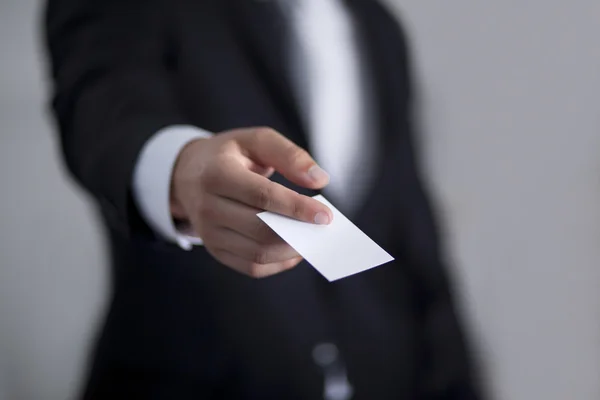 Businessman giving to someone blank business card — Stock Photo, Image
