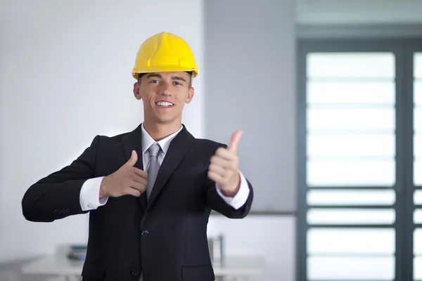 Succesvolle zakenman met gele helm vormt en met de hand gesturi — Stockfoto