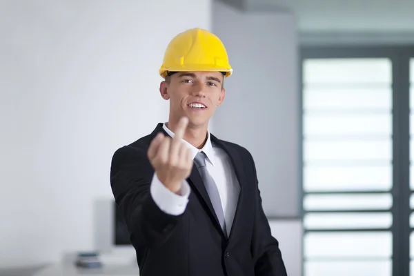 Jonge zakenman dragen een veiligheid hoed en vinger gebaren fuck — Stockfoto