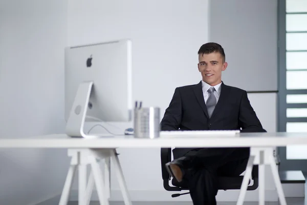 Jonge zakenman werken met een computer en zittend op de Bank — Stockfoto