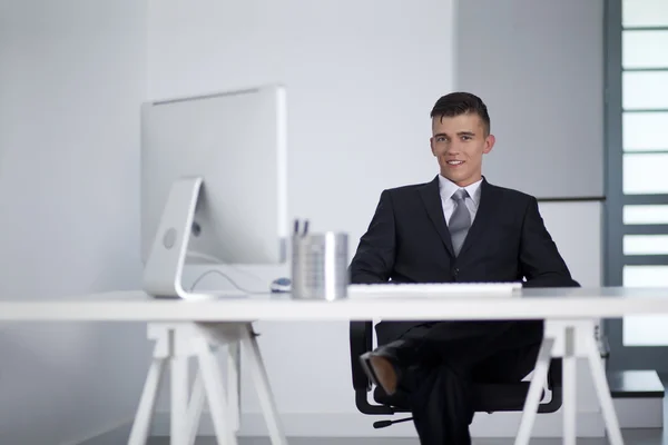 Giovane uomo d'affari che lavora con un computer e seduto sul divano — Foto Stock