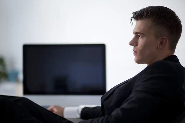 Jeune homme d'affaires travaillant avec un ordinateur et assis sur le canapé — Photo