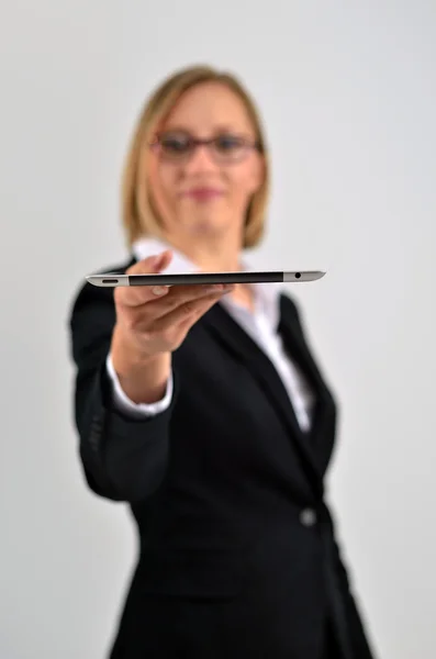 Smiling young businesswoman presents to us a tablet pc — Stock Photo, Image