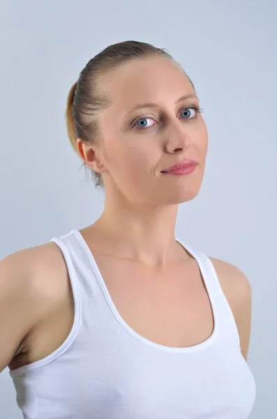 Attraktive athletische blonde Frau, die zu uns schaut und lächelt — Stockfoto