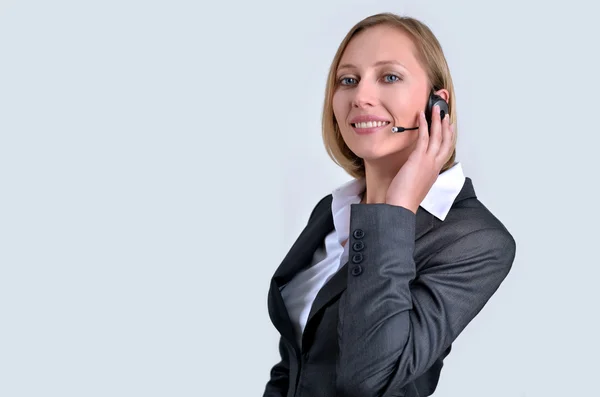 Успішна бізнес-леді з навушниками, що розмовляють по телефону — стокове фото