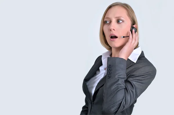 Empresária bem sucedida com fone de ouvido falando no telefone — Fotografia de Stock