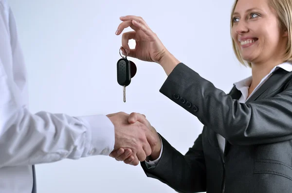 Successful businesswoman giving keys to businessman — Stock Photo, Image
