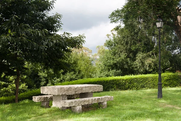 Banco de piedra solitario en un parque —  Fotos de Stock