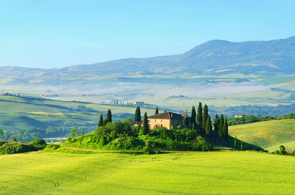 Tuscan farmhouse and cypress trees on a hill — Stock Photo, Image