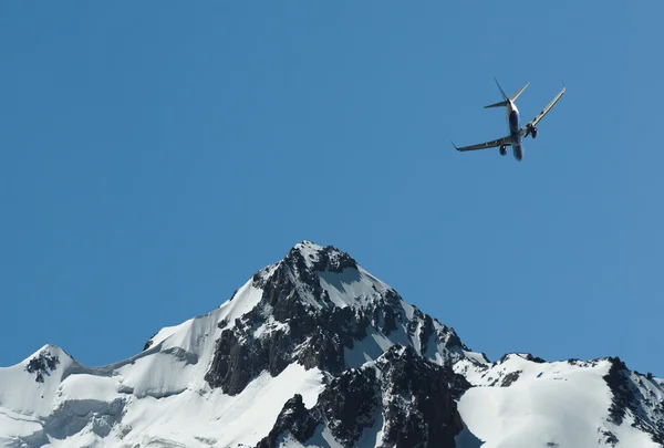 Das Flugzeug über den Bergen — Stockfoto