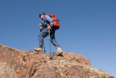 turist kayalık bir tepe üzerinde çalışır