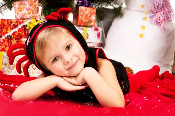 Een meisje onder de kerstboom met geschenken — Stockfoto