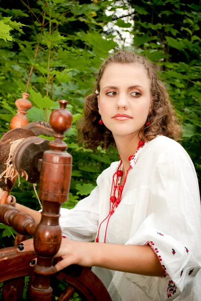 Ukrainian woman sits and spins a strand — Stock Photo, Image