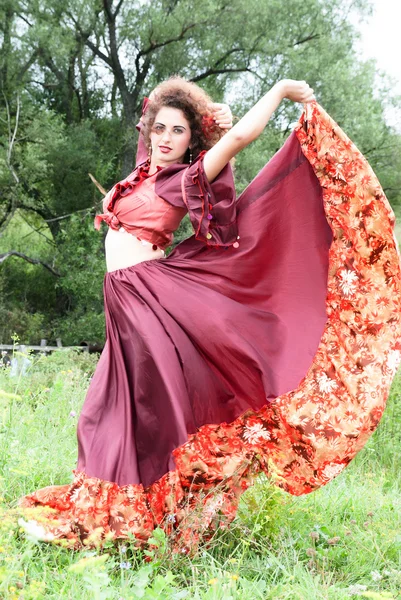 Beautiful gypsy girl in red dress — Stock Photo, Image