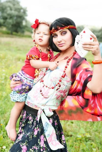 Menina cigana bonita em um vestido vermelho com o bebê. Adivinhas nas cartas — Fotografia de Stock