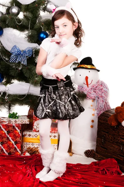 Ένα κορίτσι στέκεται κοντά σε ένα χριστουγεννιάτικο δέντρο — Φωτογραφία Αρχείου