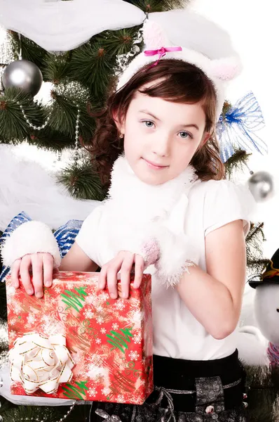 Une fille sous le sapin de Noël avec des cadeaux — Photo