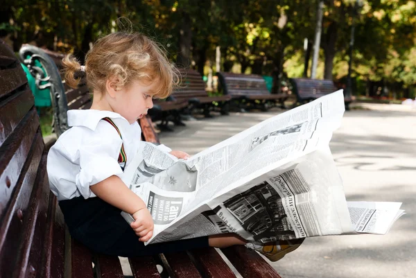 Meisje lezen van een krant — Stockfoto
