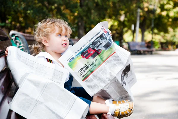 Girl reading a newspaper. — Stock Photo, Image