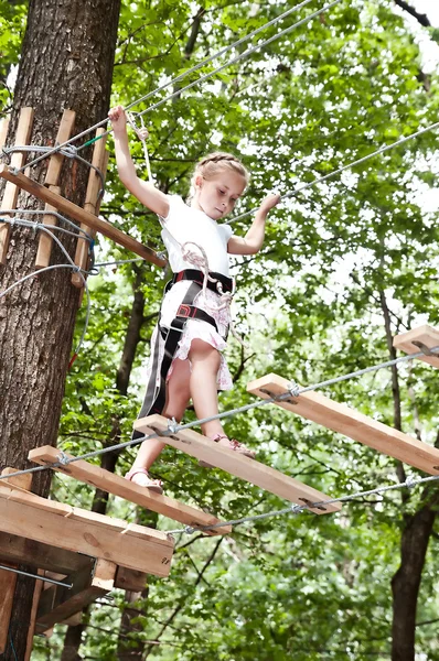 Молодая девушка балансирует на веревке в приключениях восхождение на канате пар — стоковое фото