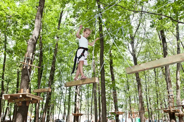 Giovane ragazza in equilibrio sulla corda in avventura arrampicata alto filo par — Foto Stock