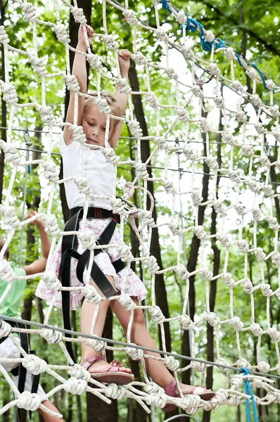 Jong meisje balanceren op touw in avontuur klimmen hoge draad par — Stockfoto