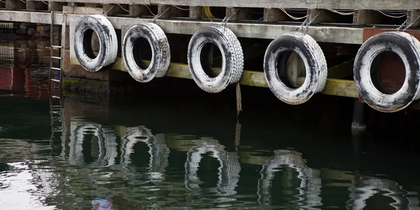 Fila de neumáticos viejos para proteger los barcos —  Fotos de Stock