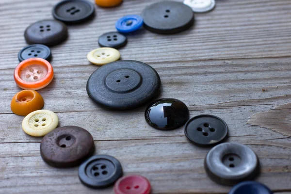 Винтажные кнопки на старом деревянном столе — стоковое фото